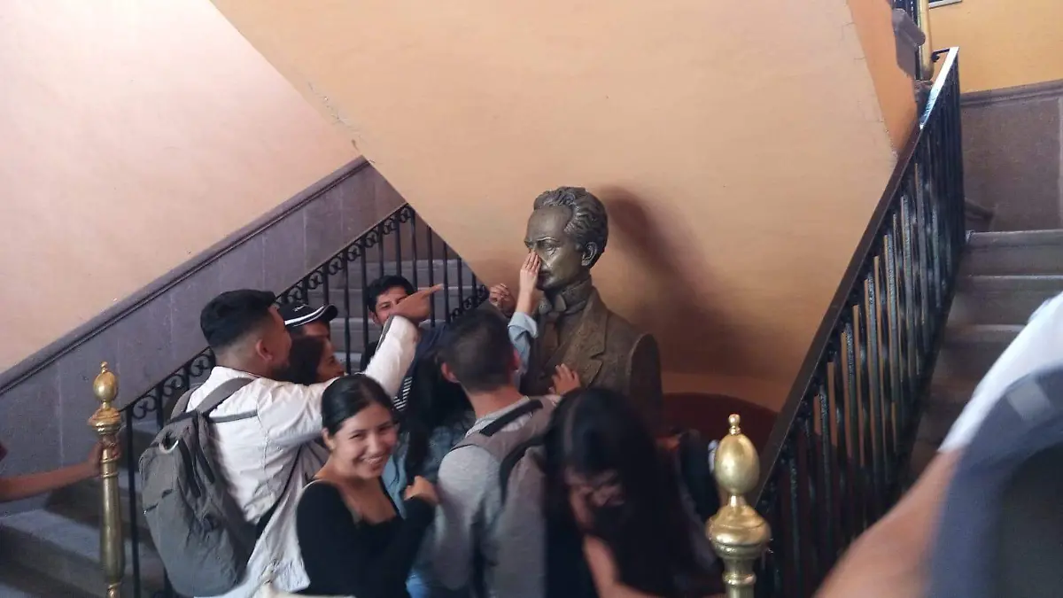 jovenes tocan la mnariz del busto de UASLP PC (1)